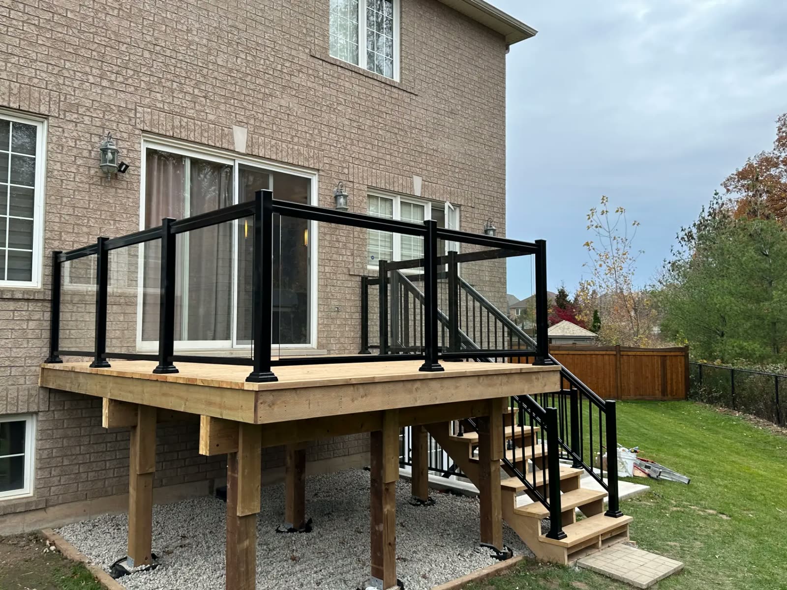 Black framed glass railing on a cedar deck and stairs