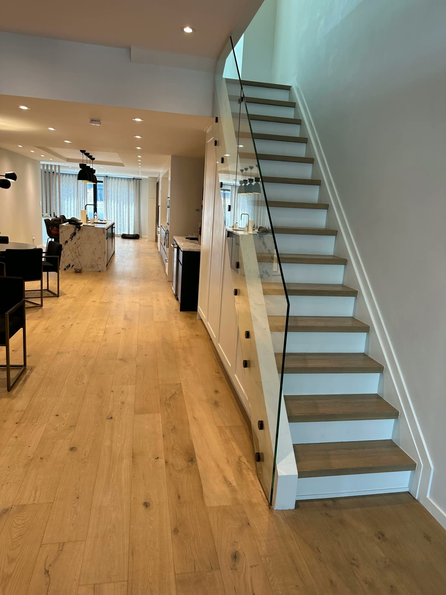Frameless glass stair railing with black standoff fittings